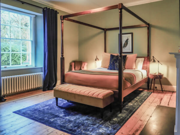 A bed with a wooden frame. Sancreed House Retreat